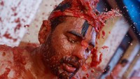 Seorang peserta diguyur bubur tomat selama festival La Tomatina.