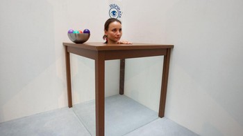 Berfoto di depan kamera, kepala perempuan ini terlihat dengan badan yang hilang di kolong meja. Foto ini diambil pada 25 Juni 2013 lalu di Jerman.