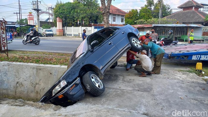 Kondisi mobil sedan yang terperosok di selokan di Jalan Jenderal Sudirman, Kelurahan Bulakrejo, Sukoharjo, Kamis (1/9/2022).