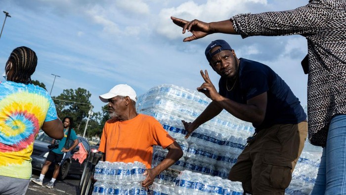 Krisis Air Bersih Melanda Negara Bagian Mississippi AS JACKSON, MS - AUGUST 31: Cases of bottled water are handed out at a Mississippi Rapid Response Coalition distribution site on August 31, 2022 in Jackson, Mississippi. Jackson is experiencing a third day without reliable water service after river flooding caused the main treatment facility to fail. Late Tuesday night, President Joe Biden declared an emergency amid the crisis. (Photo by Brad Vest/Getty Images)