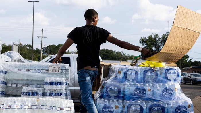 Krisis Air Bersih Melanda Negara Bagian Mississippi AS JACKSON, MS - AUGUST 31: Cases of bottled water are handed out at a Mississippi Rapid Response Coalition distribution site on August 31, 2022 in Jackson, Mississippi. Jackson is experiencing a third day without reliable water service after river flooding caused the main treatment facility to fail. Late Tuesday night, President Joe Biden declared an emergency amid the crisis. (Photo by Brad Vest/Getty Images)