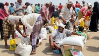 Pengungsi mengambil paket bantuan dengan tertib. Perserikatan Bangsa-Bangsa (PBB) menyebut perang saudara di Yaman adalah krisis kemanusiaan terburuk di dunia. (Khaled Ziad/AFP/Getty Images)  