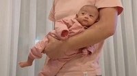 Walaupun masih banyak yang menganggap posisi ini berbahaya, teknik menggendong ini ternyata bisa membuat Baby Moana nyaman di pelukan ayahnya. Foto: Instagram Ria Ricis (@riaricis1795)