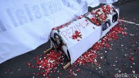Massa turut membawa sebuah keranda. Pada keranda itu tertempel beberapa foto menteri di antaranya Mendag Zulkifli Hasan, Menteri BUMN Erick Thohir, Menkeu Sri Mulyani, dan Dirut Pertamina Nicke Widyawati.