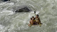 Penduduk setempat menggunakan gondola darurat untuk menyeberangi sungai di Swat Bahrain, Khyber Pakhtunkhwa, Pakistan, Rabu, (31/8/2022). Di bawahnya, terlihat arus Sungai Swat terlihat kencang setelah hujan turun pada malam sebelumnya.