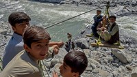 Anak-anak menarik gondola darurat. Meski berbahaya, gondola darurat menjadi andalan warga untuk menyeberangi Sungai Swat.