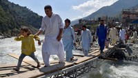 Warga menyeberangi Sungai Swat menggunakan jembatan darurat di Swat Bahrain, Khyber Pakhtunkhwa, Pakistan.