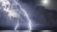 Pada malam bulan purnama, ada badai bergerak menjauh dan satu sambaran petir terakhir dan itu direkam oleh fotografer Enric Navarrete Bachs.
