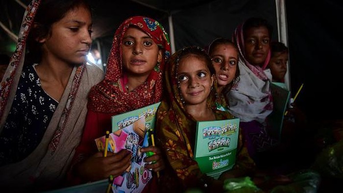 Flood-affected children attend a class at a makeshift school run by the Charity Al-Khidmat Foundation in Sukkur, Sindh province, on September 1, 2022. - Monsoon rains have submerged a third of Pakistan, claiming at least 1,190 lives since June and unleashing powerful floods that have washed away swathes of vital crops and damaged or destroyed more than a million homes. (Photo by Asif HASSAN / AFP) (Photo by ASIF HASSAN/AFP via Getty Images)