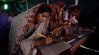 Para siswa tekun menyelesaikan pelajaran meski belajar di tenda darurat. Anak-anak terpaksa harus meninggalkan rumah mereka yang hancur dan tinggal di pengungsian.
