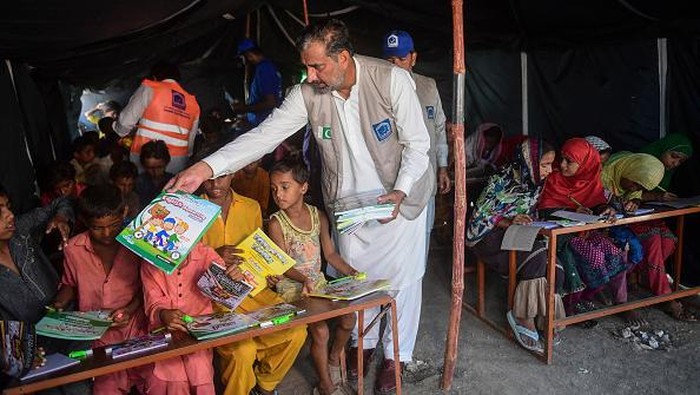 Flood-affected children attend a class at a makeshift school run by the Charity Al-Khidmat Foundation in Sukkur, Sindh province, on September 1, 2022. - Monsoon rains have submerged a third of Pakistan, claiming at least 1,190 lives since June and unleashing powerful floods that have washed away swathes of vital crops and damaged or destroyed more than a million homes. (Photo by Asif HASSAN / AFP) (Photo by ASIF HASSAN/AFP via Getty Images)