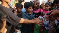 Anak-anak kecil rebutan untuk mengisi air minum ke dalam botol yang sudah mereka bawa.
