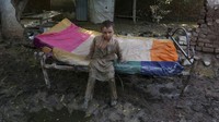 Seorang anak laki-laki berdiri di lumpur setelah banjir melanda rumahnya, di Charsadda, Pakistan, Rabu (31/8/2022). Banjir bandang telah menghancurkan sebagian besar wilayah Pakistan. (AP Photo/Mohammad Sajjad)  