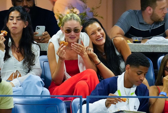 Inilah salah satu momen manis Gigi Hadid dan Bella Hadid saat menonton US Open. Kakak dan adik yang berbeda usia dua tahun ini tampak tertawa lepas bersama. Foto: Dok. Photo by Gotham/GC Images, Jean Catuffe/GC Image