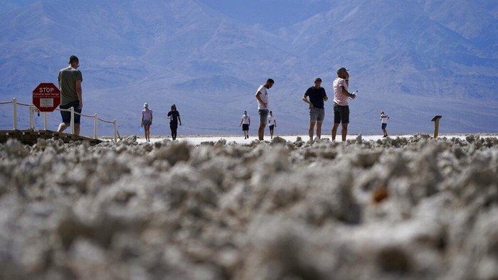 People visit a thermometer at the Furnace Creek Visitor Center, Thursday, Sept. 1, 2022, in Death Valley National Park, Calif. The thermometer is not official but is a popular photo spot. (AP Photo/John Locher)