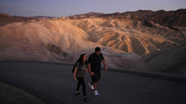 Sepasang turis melintasi Death Valley yang terkenal dengan pemandangannya. Akhir tahun lalu, lembah ini jadi tempat terpanas di dunia. Â Sepasang turis melintasi Death Valley yang terkenal dengan pemandangannya. Akhir tahun lalu, lembah ini jadi tempat terpanas di dunia. Â