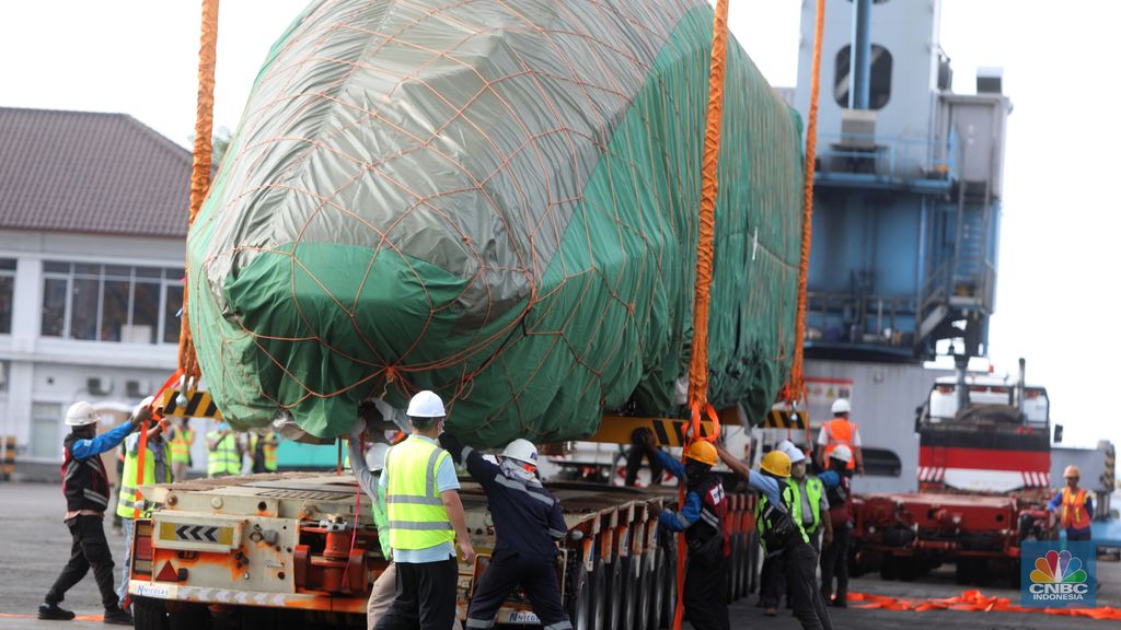 Pekerja dengan menggunakan alat berat melakukan bongkar muat Electric Multiple Unit (EMU) atau kereta untuk proyek Kereta Cepat Jakarta-Bandung (KCJB) yang tiba di Pelabuhan Tanjung Priok, Jumat (2/8/2022).  (CNBC Indoensia/Andrean Kristianto)