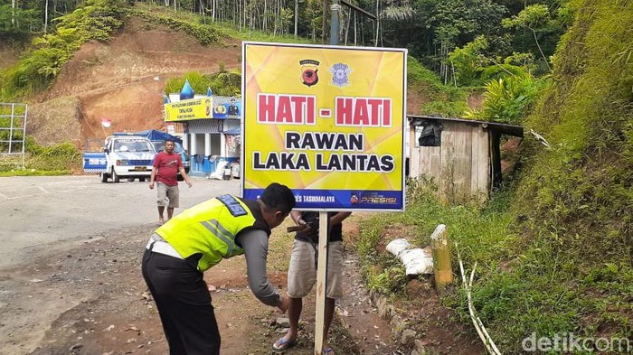 Polisi memasang rambu peringatan.