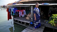 Wahidah berdiri di depan rumahnya bersama teman-temannya, Minggu (31/7/2022). Ia mengatakan bahwa Tidak ada tempat untuk pergi. Saya pikir generasi muda harus pindah. Jika mereka punya uang, mereka harus membeli tanah. Tapi saya tidak punya uang sekarang, jadi saya tetap tinggal.