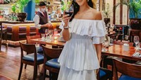 Berada di sebuah restoran fine dining, begini momen Ririn saat akan menikmati makan malam. Ia menggunakan gaun putih yang cantik. Foto: Instagram @myririz
