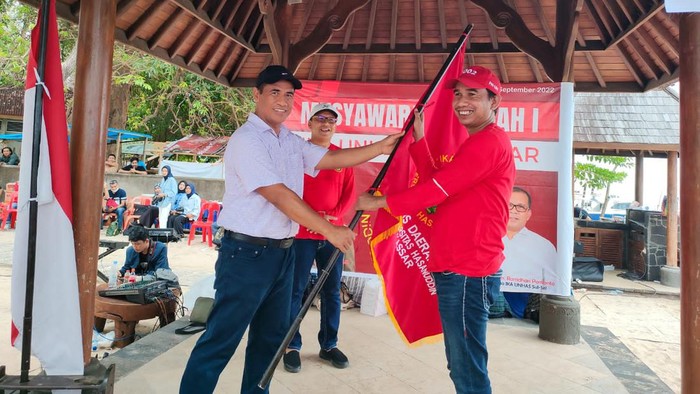 Ketua Umum IKA Unhas Andi Amran Sulaiman menyerahkan bendera pataka kepada Ketua Formatur IKA Unhas Makassar Rudianto Lallo.