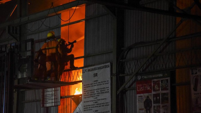 Petugas berupaya memadamkan api yang membakar pabrik plastik di Jalan Setia Ujung, Sungal, Deli Serdang, Sumatera Utara, Jumat (2/9/2022) malam. Dinas Pemadam kebakaran mengerahkan sebanyak 13 unit mobil pemadam untuk mengatasi kebakaran pabrik tersebut.  ANTARA FOTO/Fransisco Carolio/Ief/rwa.