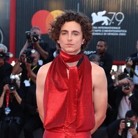 Aksen dasi di leher yang menjuntai hingga dada memberi sentuhan unik pada blouse berwarna merah rubi metalik ini. Foto: Daniele Venturelli/Getty Images