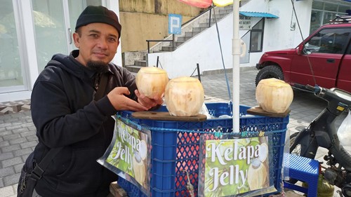 Salamuddin dengan Kelapa Muda Jelly dagangannya yang dijajakan depan Masjid Besar Al Hidayah, Bedugul, Minggu (4/9/2022).