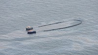 Dua kapal mengendalikan tumpahan minyak dari kapal kargo OS 35 setelah bertabrakan dengan kapal tanker LNG di Catalan Bay, lepas pantai Gibraltar. (REUTERS/Jon Nazca)