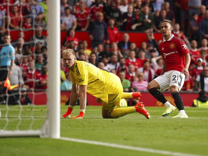 Manchester United's Antony, right, scores his side's opening goal past Arsenal's goalkeeper Aaron Ramsdale during the English Premier League soccer match between Manchester United and Arsenal at Old Trafford stadium, in Manchester, England, Sunday, Sept. 4, 2022. (AP Photo/Dave Thompson)