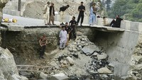 Tebing jalan yang longsor akibat banjir bandang di Pakistan. Pemerintah setempat memperkirakan nilai kerusakan setidaknya mencapai 10 miliar dolar Amerika Serikat.  