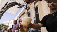 Seorang bartender menuang bir ke dalam gelas untuk pengunjung. Bir Taybeh dibuat dari anggur yang tumbuh di kebun anggur dekat Kota Birzeit, Tepi Barat, sekitar 10 kilometer timur laut Ramallah.