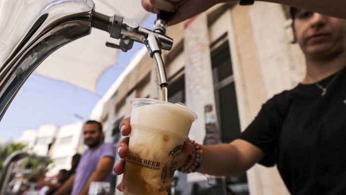 Visitors gather on September 2, 2022, during the annual annual Oktoberfest beer festival in the village of Taybeh in the village of Taybeh, east of the occupied West Bank city of Ramallah, home of the Palestinian Taybeh brewery founded in 1994. - Ever since 2005, the Taybeh brewery has been brewing beer under challenging circumstances. Now the brewery is run by a woman, Madees Khoury, adding an extra layer of complication. Run as a two-day weekend event, Oktoberfest at Taybeh is as much about Palestinian identity as it is about drinking beer. (Photo by Abbas MOMANI / AFP) (Photo by ABBAS MOMANI/AFP via Getty Images)
