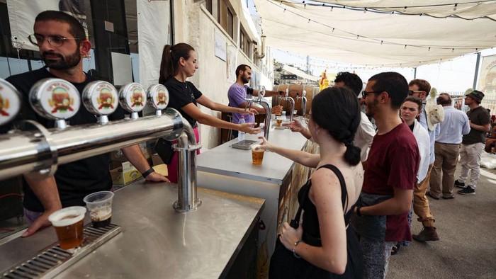 Visitors gather on September 2, 2022, during the annual annual Oktoberfest beer festival in the village of Taybeh in the village of Taybeh, east of the occupied West Bank city of Ramallah, home of the Palestinian Taybeh brewery founded in 1994. - Ever since 2005, the Taybeh brewery has been brewing beer under challenging circumstances. Now the brewery is run by a woman, Madees Khoury, adding an extra layer of complication. Run as a two-day weekend event, Oktoberfest at Taybeh is as much about Palestinian identity as it is about drinking beer. (Photo by Abbas MOMANI / AFP) (Photo by ABBAS MOMANI/AFP via Getty Images)