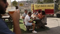 Orang-orang berkumpul untuk menikmati bir Taybeh. Berlokasi sekitar 35 kilometer dari utara Yerusalem, Desa Taybeh menjadi surga bagi penikmat bir non alkohol.