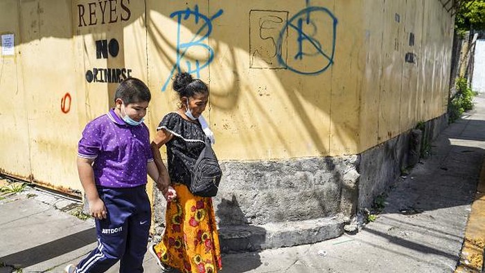 Camilo Freedman/Getty Images A woman sells fruit at a stand next to a sign against the use of Bitcoin on September 4, in San Salvador, El Salvador. On September 7th, 2021, El Salvador became the first country to make a Cryptocurrency legal tender after the Salvadoran Congress approved Bitcoin to circulate as currency in the Central American country. (Photo by Camilo Freedman/NurPhoto via Getty Images)
