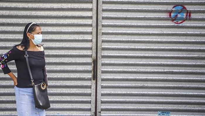 A woman sells fruit at a stand next to a sign against the use of Bitcoin on September 4, in San Salvador, El Salvador. On September 7th, 2021, El Salvador became the first country to make a Cryptocurrency legal tender after the Salvadoran Congress approved Bitcoin to circulate as currency in the Central American country. (Photo by Camilo Freedman/NurPhoto via Getty Images)