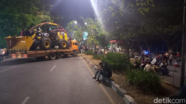 Mahasiswa menutup jalan menggunakan truk kontainer yang memuat alat berat.