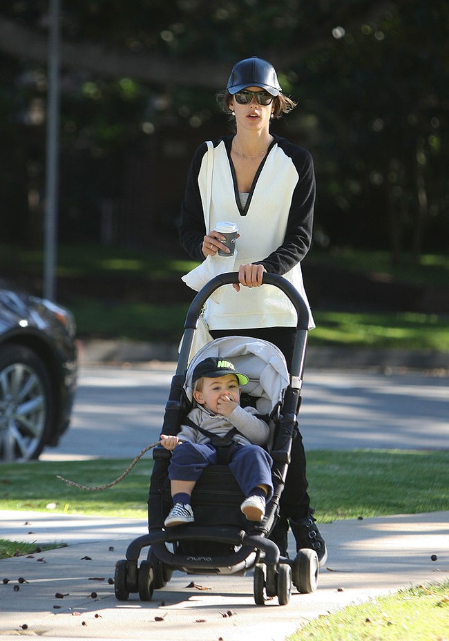 Alessandra Ambrosio vergaya monokrom dengan blouse oversized hitam-putih, topi baseball dan kacamata hitam. Sneakers berwarna senada membuat tampilan casual-nya terlihat nyaman. Foto: GC Images/Bauer-Griffin