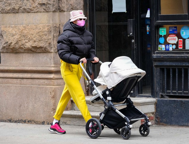 Gigi Hadid memilih tampilan ngejreng dengan setelan sweater kuning, sneakers warna fuchsia dan puffy jacket. Foto: GC Images/Gotham