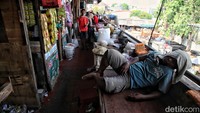 Pedagang beristirat di antara barang dagangannya. 