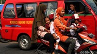Angkot melintas di samping kendaraan roda dua dengan 5 penumpang. Selain harga BBM Pertalite, ada kenaikan solar bersubsidi dari Rp 5.150 per liter menjadi Rp 6.800 per liter, dan Pertamax non-subsidi dari Rp 12.500 per liter menjadi Rp 14.500 per liter.  