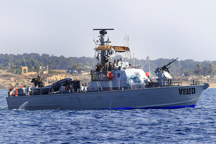 Lebanese protesters on a motorboat carry their national flag as they sail in front on an Israeli Navy vessel during a demonstration demanding Lebanon's right to its maritime oil and gas fields, in the southern marine border town of Naqoura, Lebanon, Sunday, Sept. 4, 2022. The protest came days before the mediating U.S. envoy is scheduled to land in Beirut to continue maritime border talks. (AP Photo/Mohammed Zaatari)