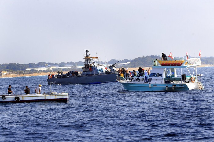 Lebanon Israel Lebanese protesters on a motorboat carry their national flag as they sail in front on an Israeli Navy vessel during a demonstration demanding Lebanon's right to its maritime oil and gas fields, in the southern marine border town of Naqoura, Lebanon, Sunday, Sept. 4, 2022. The protest came days before the mediating U.S. envoy is scheduled to land in Beirut to continue maritime border talks. (AP Photo/Mohammed Zaatari)