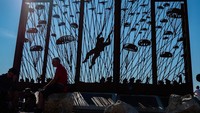 Para peserta beristirahat di dekat Landmark Lintas Udara karya seniman Karin Colen. Karya tersebut melambangkan penjatuhan sekitar 1900 pasukan terjun payung dan kontainer mereka selama pendaratan udara selama Perang Dunia Kedua.