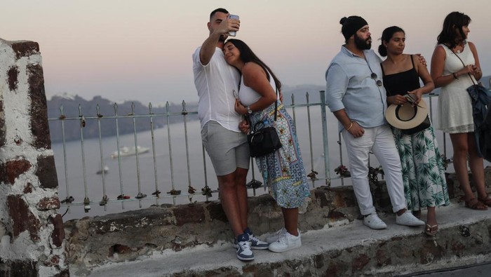 Pelancong Desar-desakan di Santorini Demi Lihat Matahari Terbenam Tourists watch the sunset from the castle of Oia, on the island of Santorini, Greece, August 30, 2022. REUTERS/Louiza Vradi TPX IMAGES OF THE DAY