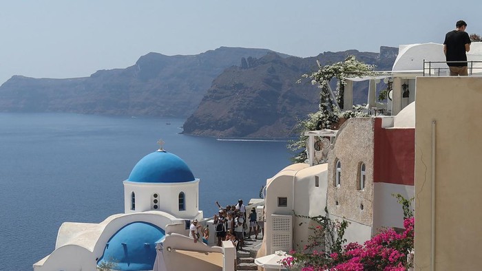 Tourists watch the sunset from the castle of Oia, on the island of Santorini, Greece, August 30, 2022. REUTERS/Louiza Vradi     TPX IMAGES OF THE DAY