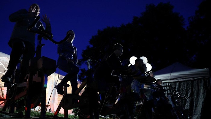 Polandia Bikin Bioskop Ramah Lingkungan, Listriknya dari Sepeda Statis People pedal stationary bikes and generate up to 50% of the energy at a pop-up outdoor cinema in a park in Warsaw, Poland September 2, 2022. REUTERS/Kacper Pempel TPX IMAGES OF THE DAY