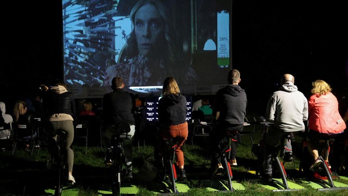 Polandia Bikin Bioskop Ramah Lingkungan, Listriknya dari Sepeda Statis People pedal stationary bikes and generate up to 50% of the energy at a pop-up outdoor cinema in a park in Warsaw, Poland September 2, 2022. REUTERS/Kacper Pempel TPX IMAGES OF THE DAY