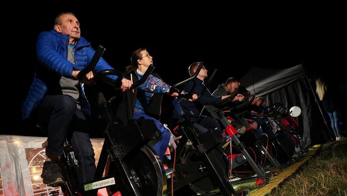 Polandia Bikin Bioskop Ramah Lingkungan, Listriknya dari Sepeda Statis People pedal stationary bikes and generate up to 50% of the energy at a pop-up outdoor cinema in a park in Warsaw, Poland September 2, 2022. REUTERS/Kacper Pempel TPX IMAGES OF THE DAY